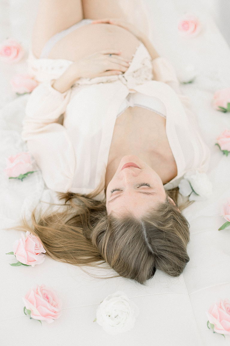 Séance photo grossesse avec roses au lit